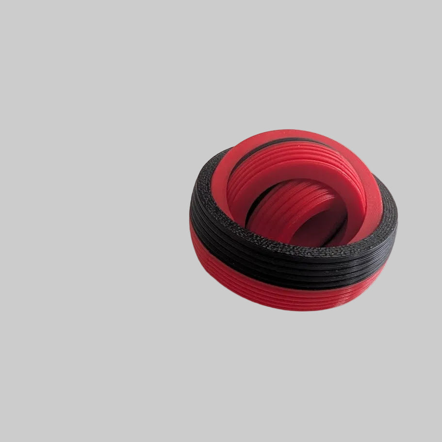 Red and black spiral object on a light gray background