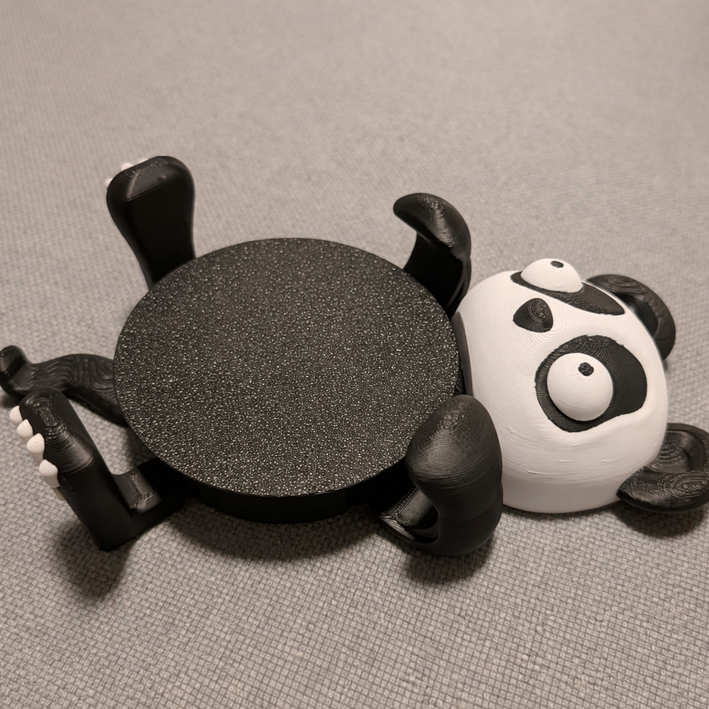 Black spider-shaped object on a gray surface