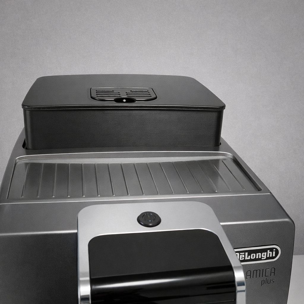 DeLonghi coffee machine with a black container on top against a gray background