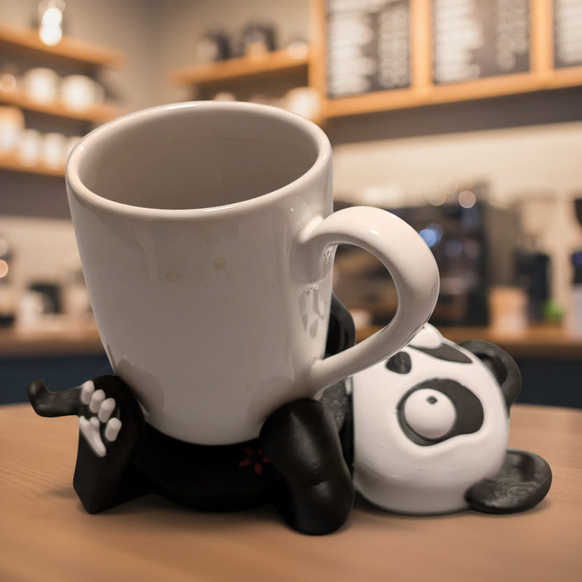 White mug on a panda-shaped stand with a blurred coffee shop background
